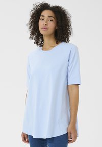 Top azzurro chiaro a maniche corte con scollatura rotonda e maniche raglan, realizzato in un tessuto liscio con una vestibilità comoda e orlo curvo.
