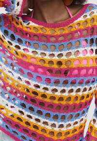 Pull en crochet multicolore avec de grands trous ouverts ; présente des rayures horizontales en rose, jaune, bleu et blanc. Léger et texturé.