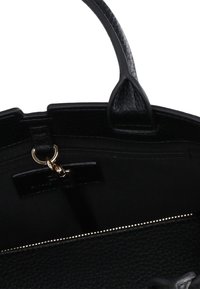 Czarna skórzana torebka z teksturowanym wykończeniem, górnymi uchwytami, wewnętrzną kieszenią na zamek błyskawiczny oraz metalowym zamkiem. Posiada miękką podszewkę z tkaniny.