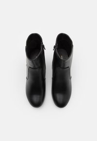 Svarta läderankelstövlar med en slät yta, sidogylf, rund tå och minimalistisk design; platta sulor och mjukt inre foder.