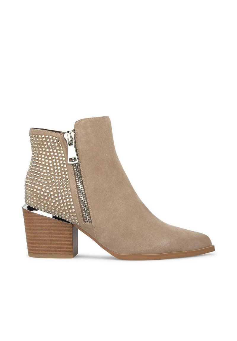 Bottes en matériau suédine beige, à bout pointu, avec fermeture éclair sur le côté et clous décoratifs métalliques à l'arrière, dotées d'un talon empilé.