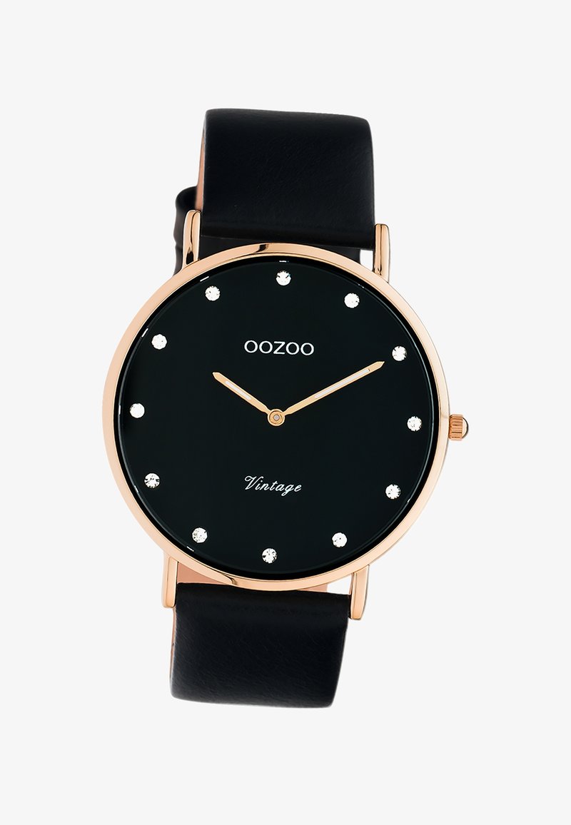 Montre noire ronde avec des accents dorés, marqueurs d'heure sertis, et un bracelet en cuir. Présente "OOZOO" et "Vintage" en texte blanc sur le cadran.