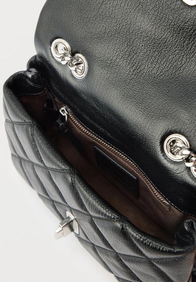 Μαύρη καπιτονέ δερμάτινη τσάντα χειρός με αλυσίδες ασημί λουριά και ανοιχτή κορυφή που αποκαλύπτει το καφέ εσωτερικό και τσέπη με φερμουάρ.