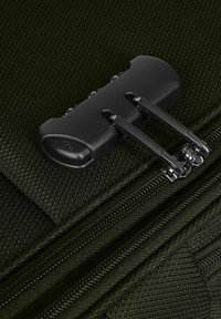 Hardware con zip nera su tessuto verde scuro testurizzato, dotato di impugnatura moldata e meccanismo a doppio cursore per una facile apertura e chiusura.