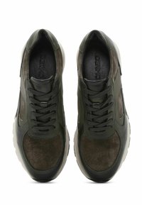 Zapatillas de cuero y ante verde oscuro con un acabado texturizado, que cuentan con cordones negros, punta redondeada y suela de goma blanca.