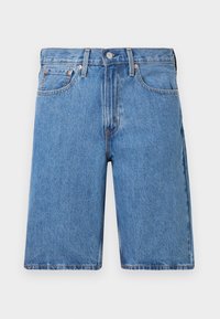 Siniset farkkushortsit, joissa on suora leikkaus, viisi taskua ja kuparinväriset yksityiskohdat. Klassinen vyötärö ja raakareuna.