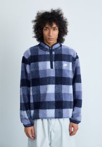 Pullover in fleece blu e navy con motivo a quadri, dotato di collo a zip e logo ricamato. Tessuto morbido e vestibilità comoda.