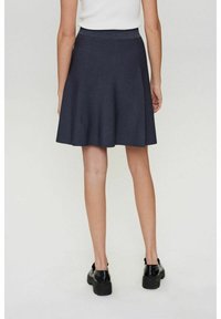 Tummanharmaa levenevä hame, valmistettu teksturoidusta kankaasta, jossa on vartalonmyötäinen vyötärö ja helma, joka ulottuu polvien yläpuolelle.