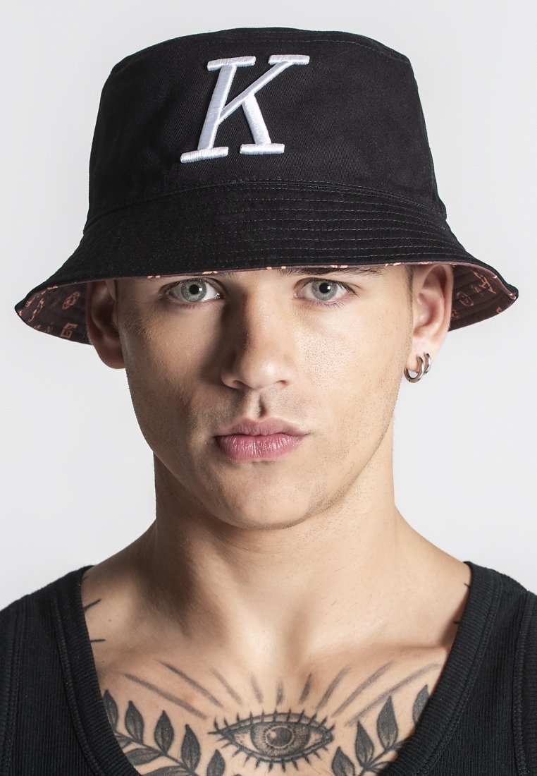 Cappello a secchiello nero con logo "K" bianco, presentante un interno a fantasia. Realizzato in tessuto, ha una visiera ampia e una vestibilità comoda.