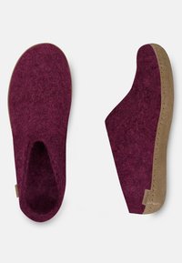 Burgundy felt slippers with a tan rubber sole, seamless design, and open back for easy wear. Featuring minimal stitching and branding accents.