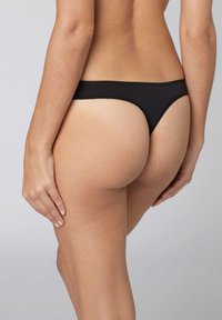 Perizoma nero in materiale liscio, caratterizzato da un design minimalista con sottili cinghie laterali e un retro a vita bassa.