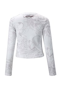 Pitkähihaisen valkoisen paidan, jossa on hienovarainen harmaa eläin- ja tekstikuosisuunnittelu. Brändin nimi "Ed Hardy" painettuna taka-kauluksessa.