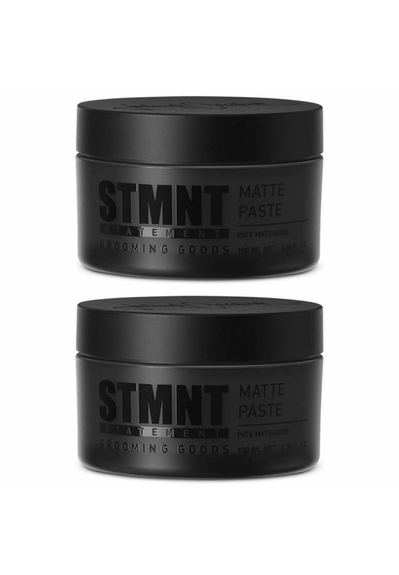 Two black, matte jars of STMTNT Matte Paste, each 100 ml, labeled clearly with product and brand information in bold gray text.