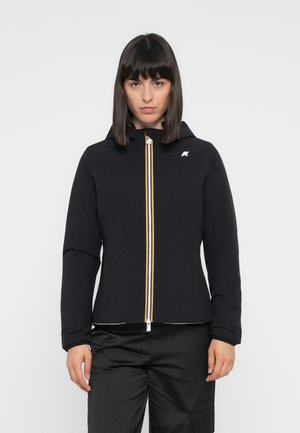 Zwarte hoodie met een rits aan de voorkant, voorzien van gele en witte strepen. Gemaakt van een gladde, lichte stof. Meerdere zakken zichtbaar.