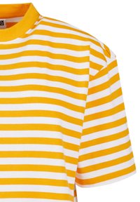 T-shirt à manches courtes rayé jaune et blanc avec un col rond ; matière en coton douce ; motif à rayures horizontales de largeur égale.