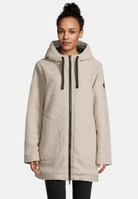 Beige Fleece-Jacke mit Kapuze, ausgestattet mit einem Frontreißverschluss, schwarzen Akzenten und einer strukturierten Oberfläche, entworfen für Wärme und Komfort.