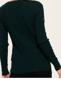 Dunkelgrüner Strickpullover mit Kabelmuster, langen Ärmeln und taillierter Passform. Verfügt über ein Logopatch auf der linken Schulter.