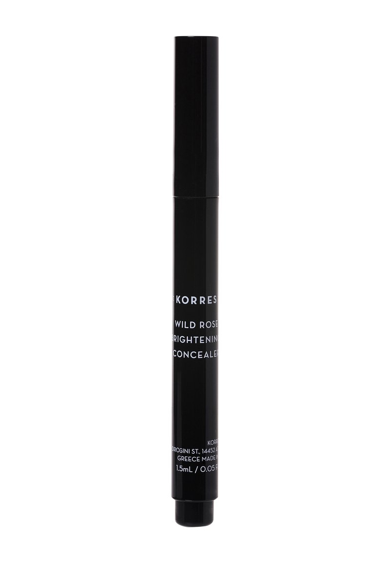 Tubetto di correttore cilindrico nero con meccanismo a vite, etichettato "Korres Wild Rose Brightening Concealer", capacità di 1,5 mL.