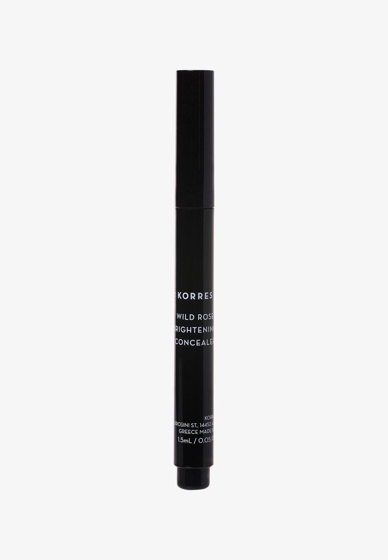 Tube de correcteur cylindrique noir avec un mécanisme à vis, étiqueté "Korres Wild Rose Brightening Concealer," capacité de 1,5 mL.