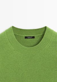 Zielony sweter z okrągłym dekoltem, wykonany na drutach, z prążkowanym kołnierzem i czarną metką z napisem "Massimo Dutti Made in China".