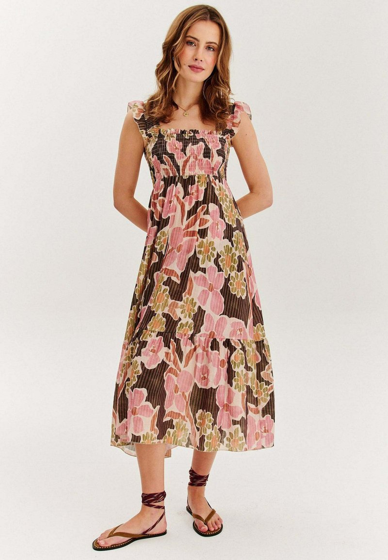Kvetinové šaty s gumičkovanou hruďou v ružovej, zelenej a hnedej farbe. Obsahujú vrstvený dizajn a volánové ramienka. Ľahký materiál.