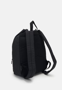 Sac à dos noir avec un panneau arrière rembourré en maille, des bretelles ajustables et un design épuré. Présente une surface texturée et des compartiments zippés.