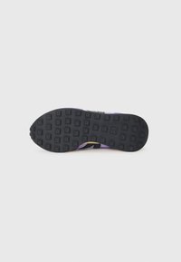 Sport shoe with a black rubber sole featuring textured grip patterns, purple upper with a sleek design, and black accents.