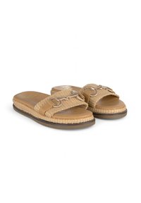 Des slippers espadrilles beiges avec des sangles en tissu tissé, des détails en métal et une semelle texturée. Présente un design plat pour un enfilage facile.
