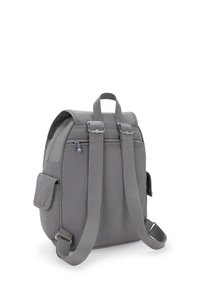 Sac à dos en tissu gris avec deux bretelles ajustables, une poigné supérieure, une poche zippée à l'avant, une poche latérale et des accents en métal argenté.