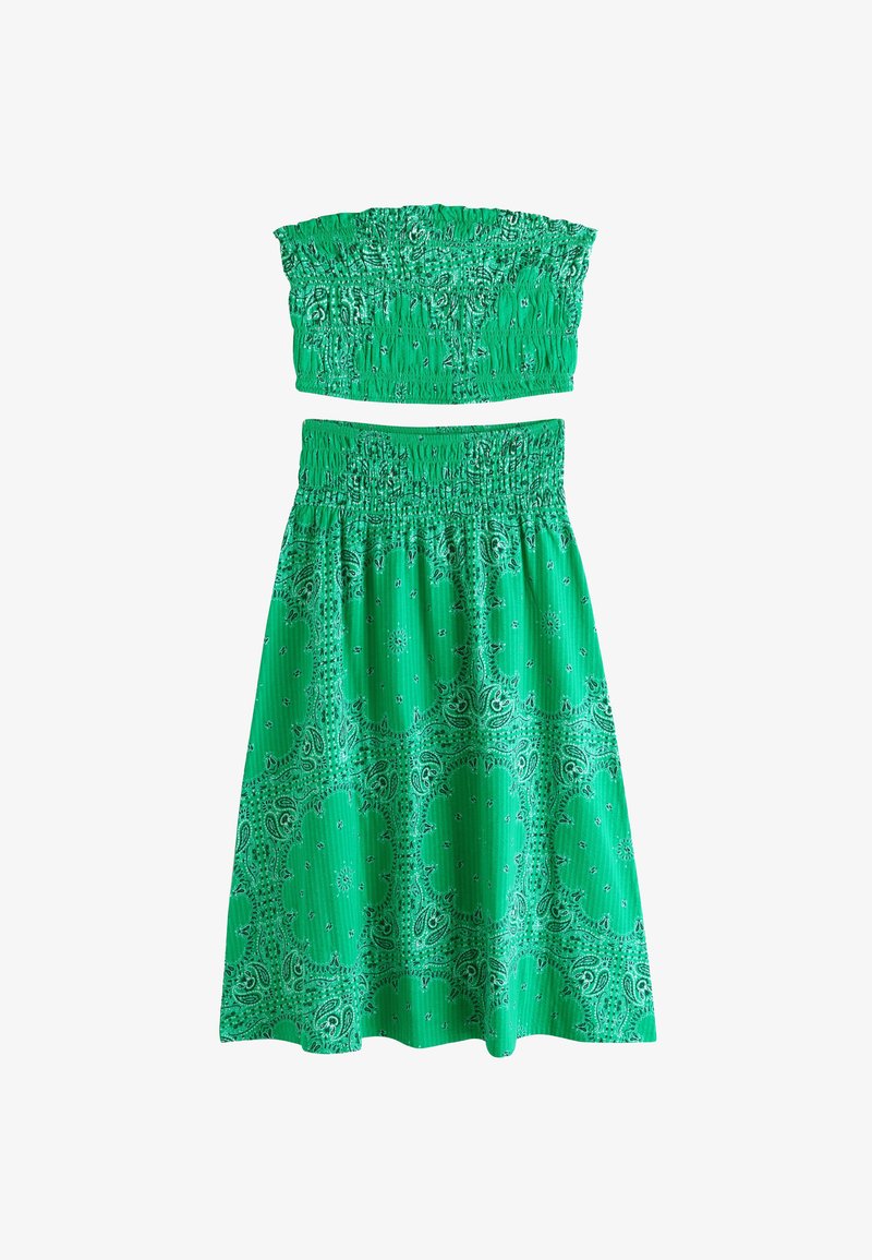Green two-piece outfit with smocked strapless top and high-waisted skirt featuring paisley and floral patterns.