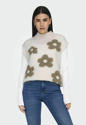Gebreide mouwloze trui met een hoge halslijn, versierd met pastelroze en olijfgroene bloemmotieven, gedragen over een lange mouw witte top.