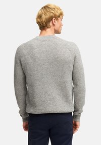 Grauer, gerippter Pullover mit langen Ärmeln und Rundhalsausschnitt, aus strukturiertem Stoff gefertigt. Verfügt über einen taillierten Saum und ein nahtloses Schulterdesign.