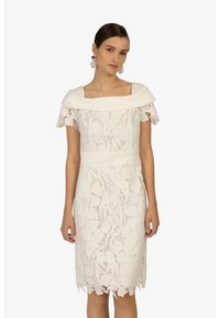 Abito in pizzo off-white con silhouette aderente, caratterizzato da un ampio scollo a barca, maniche corte e dettagli con orlo scallop.