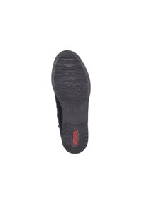 Semelle de chaussure noire avec surface en caoutchouc texturée, présentant des rainures horizontales et un logo rouge près du talon. Design plat et flexible.
