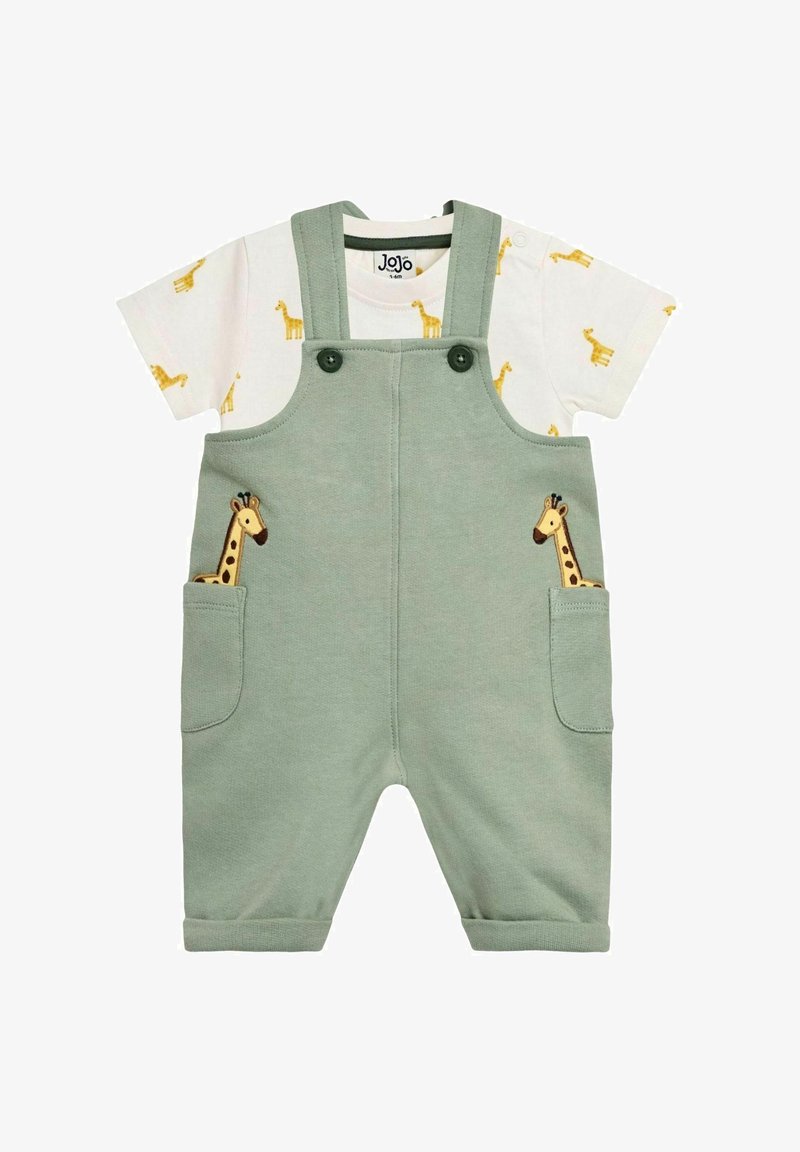 Zaļas bērnu kombinezons ar žirafes izšuvumu priekšējās kabatās, kopā ar baltu īsroku kreklu ar maziem dzelteniem žirafu rakstiem.
