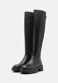 Stivali neri in pelle alti fino al ginocchio con suola spessa, caratterizzati da una finitura liscia e un design minimalista, adatti per diversi outfit.