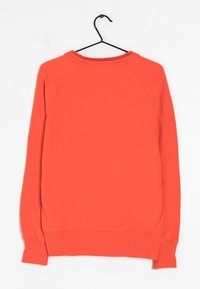 Červená mikina s kulatým výstřihem, raglánovými rukávy a žebrovanými man�žetami. Měkká textura, minimální detaily a čistý, jednobarevný design.