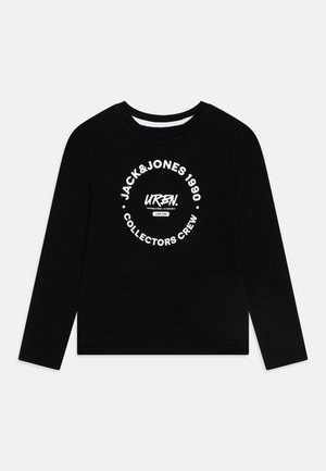 Mustan pikaäriga T-särk, mis on valmistatud puuvillast; esiküljel on valge ringikujuline graafika, millel on kirjas brändi ja kollektsiooni nimi.