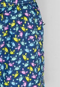Pantaloncini da bagno con sfondo blu navy caratterizzati da un motivo di granchi colorati in blu, rosa, giallo e verde; vita elastica con cordoncino.