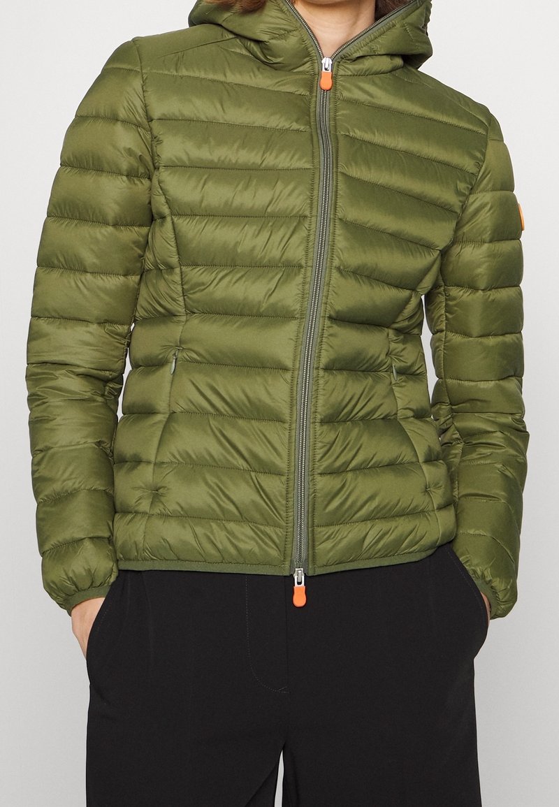 Oliven grøn pufferjakke med hætte, der har quiltet design, frontlynlås med orange trækstrop og sidelommer. Blød, glat tekstur.