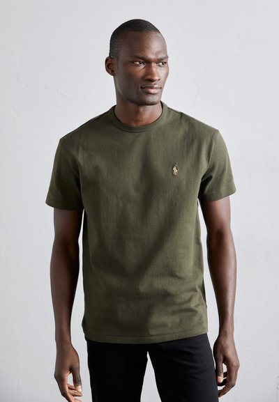 T-shirt en coton vert olive avec col rond, manches courtes et logo brodé sur la poitrine gauche. Texture lisse et coupe décontractée.
