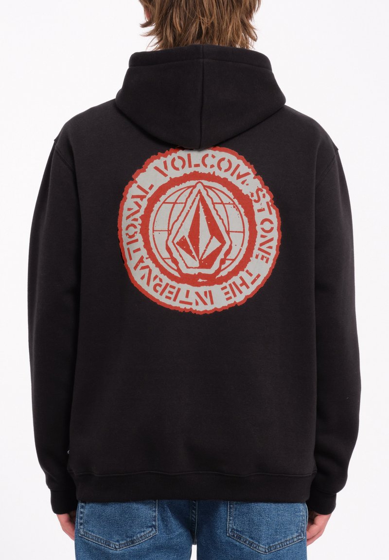 Hoodie noir avec un grand motif rouge et gris au dos, présentant un design circulaire et un logo. Le tissu semble texturé et a une coupe décontractée.