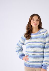 Maglione lavorato a maglia con strisce blu, bianche e verdi. Presenta un collo rotondo e polsini a coste, realizzato in morbido filato soffice.