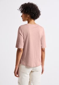 T-shirt rosa chiaro a maniche corte con scollo rotondo, realizzata in tessuto morbido, caratterizzata da una vestibilità rilassata e un orlo dritto.