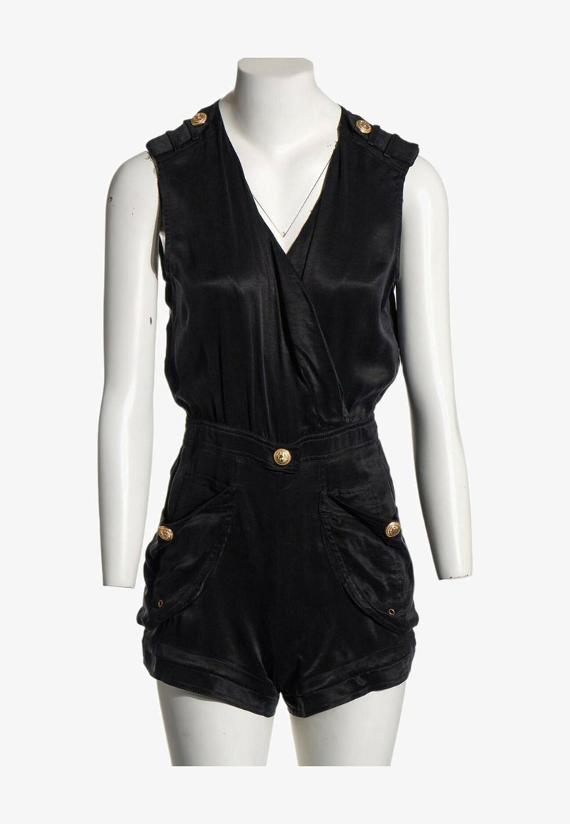 Combinaison noire sans manches avec col en V, taille haute, poches latérales et boutons décoratifs dorés aux épaules, poches et taille.