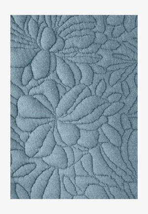 Tissu bleu clair avec un motif floral en relief, présentant des feuilles et des pétales texturés, créant une surface douce et tactile.