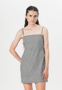 Svart og hvit gingham mini kjole med tynne stropper, firkantet hals og tettsittende silhuett, laget av et lett materiale.