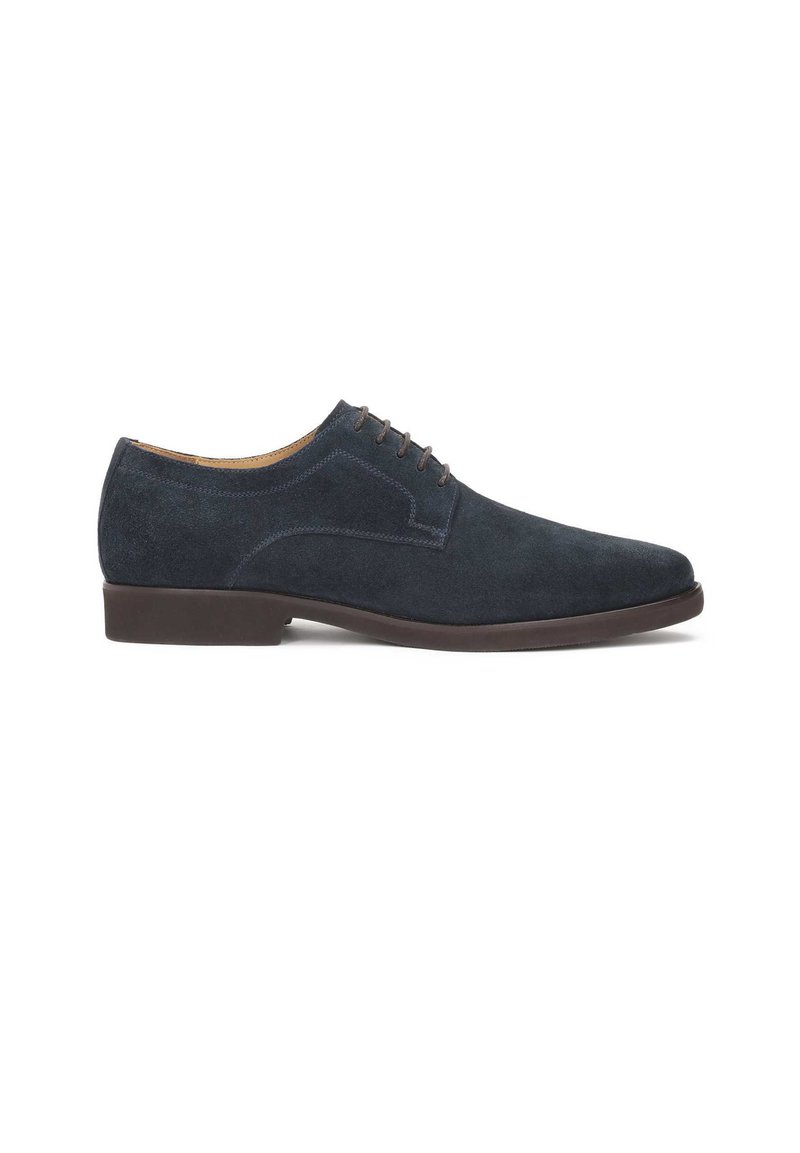 Chaussure habillée en suede bleu marine avec un bout arrondi, système de laçage à cinq œillets et intérieur en cuir lisse. Dotée d'une semelle en caoutchouc à profil bas.