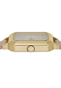 Stačiakampis auksinis laikrodis su skaidriu ciferblatu, auksinėmis rodyklėmis ir valandų žymekliais. Švelnus smėlinio atspalvio dirželis su lygiu paviršiumi. Matoma šoninė karūnėlė.