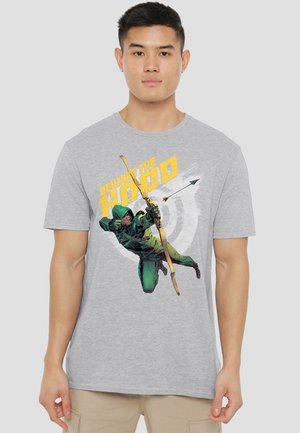 Man wearing gray t-shirt with graphic of a hooded archer aiming a bow and arrow, text "Beware the Hood" in yellow above.